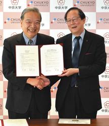 協定を締結し握手する中京大の安村学長（右）と銘伝大の李学長＝名古屋市昭和区の中京大で