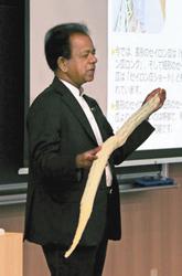 模型を手に、セイロン瓜の特徴を紹介するクマーラさん=東区矢田南の名城大ナゴヤドーム前キャンパスで