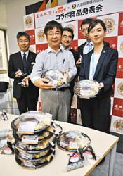 新商品の弁当とおにぎりを手にした加藤教授(手前左)ら開発関係者=名古屋市天白区の名城大で