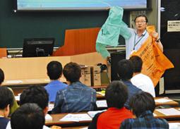 学生に美浜町の家庭ごみの現状を説明する職員＝美浜町の日本福祉大で