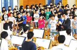 演奏に合わせてアニメ曲「勇気１００％」を元気よく歌う子どもたち＝長浜市の朝日小で