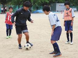 オフザボールでの動きについて生徒たちに指導する寺田監督（右から３人目）＝岐阜市の青山中で