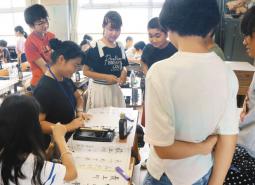 自ら筆を手にポイントを指導する学生＝岐阜市の三輪南小で