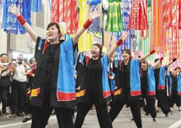 アーケードの吹き流しの下で、鮮やかな青色の法被姿で踊り、金賞に輝いたいちい信用金庫連のメンバー＝一宮市本町で