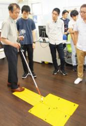 白杖のカメラで記号を読み取る仕組みを説明する千葉さん（左）＝美浜町の日本福祉大美浜キャンパスで