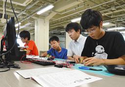 真剣な表情で回路を組み立てる参加者ら=昭和区御器所町の名古屋工業大で