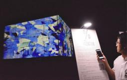 スマートフォンで投票すると建物に映す立体映像の中身が変わる「宵街映写」=犬山市の博物館明治村で