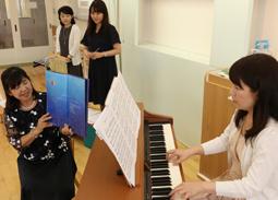 絵本ケアの練習をする真下さん（左）ら協会のメンバーたち＝稲沢市稲葉の愛知文教女子短大で