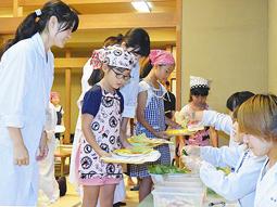 サンドイッチの具材を学生に取り分けてもらう児童＝犬山市で