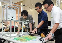 長野県の山岳を基にした立体パネルを参考に話し合う(左から)外山准教授と加藤社長、高橋営業本部長=小牧市大草の名古屋造形大で