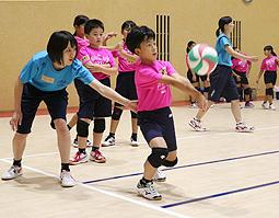 岐阜経済大の選手（左）から指導を受ける子どもたち＝８月２９日、大垣市の同大で