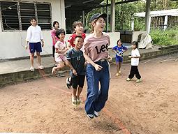 タイ北部のチェンマイで、現地の子どもたちと縄跳びをして交流を楽しむ学生たち=愛知大提供