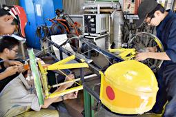 車両を組み立てる刈谷工業高の部員ら＝刈谷市の同校で