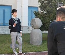 カメラマンの前でポーズを取る学生(左)=岐阜市の岐阜聖徳学園大岐阜キャンパスで