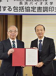 協定書を手にする塩田滋賀医大学長（左）と蔡長浜バイオ大学長＝大津市瀬田月輪町の滋賀医科大で