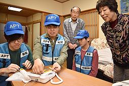 詐欺防止機能が付いた電話機を設置する学生たち＝熱田区四番で