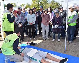 春日井東高生が演じる傷病者（中央下）の症状からトリアージの方法を紹介する中部大生（左側）＝春日井市神屋町で