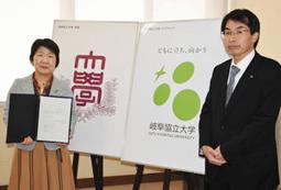 新たな学章とロゴマークを発表した山田学長（右）と我部山看護学科長＝大垣市の岐阜経済大で