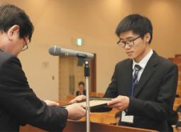 最優秀賞に選ばれ、表彰状を受け取る兪さん（右）＝岐阜市柳戸の岐阜大で