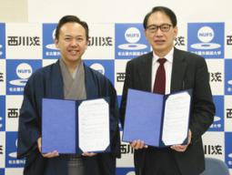 協定書を手にする亀山学長（右）と西川さん（左）＝日進市の名古屋外国語大で