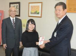 木曽広域連合の原連合長(右)に寄付金を渡す日本福祉大県人会の天野会長(中)ら=木曽町役場で