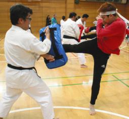 空手のミット打ちを体験する留学生ら＝日進市蟹甲町の市スポーツセンターで