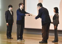 千葉教授（右から２人目）から表彰を受ける高校生＝四日市市萱生町の四日市大で