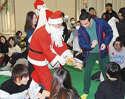 サンタから菓子のプレゼントを受け取る参加者ら＝阿久比町勤労福祉センターで