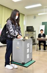 投票箱に一票を投じる学生＝大府市横根町の至学館大で