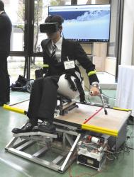 チェアスキー・シミュレーターの実演をする樋田嵩斗さん＝野々市市の金沢工業大で