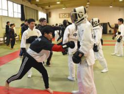 警察学校の在校生（右）を相手に、突きを繰り出す大学生＝春日井市の県警察学校で