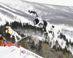 男子デュアルモーグル決勝　２位に入った堀島行真のエア。左は優勝したミカエル・キングズベリー＝たざわ湖スキー場で