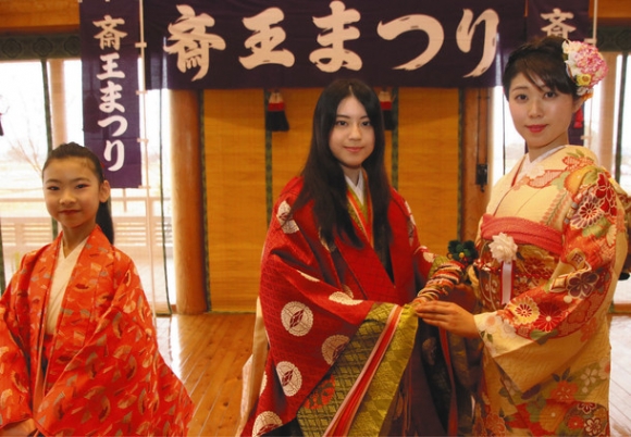 中保さんから檜扇を受け取る橋本さん（中）と、子ども斎王役の飛矢地さん（左）＝明和町のいつきのみや歴史体験館で