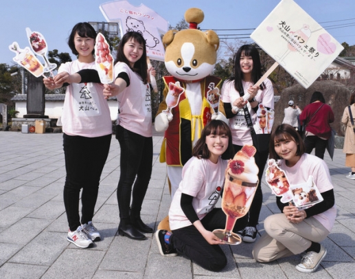 シメパフェをＰＲする金城学院大の学生と市キャラクターわん丸君＝犬山市の犬山城前で