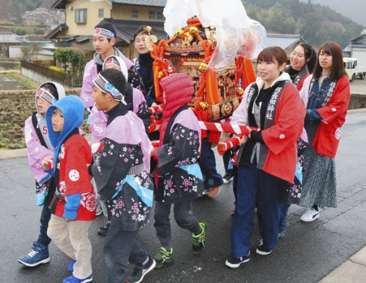 子どもたちと一緒にみこしを担ぐ学生たち＝白川町切井で