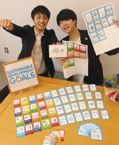 カードゲームをＰＲする島田高行代表（左）ら＝野々市市の金沢工業大で