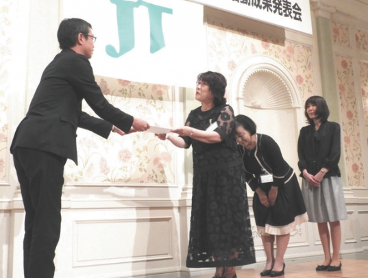 助成金交付書を受け取る四日市大学エネルギー環境教育研究会の矢口副会長（右から３人目）＝名古屋市中村区のホテルで