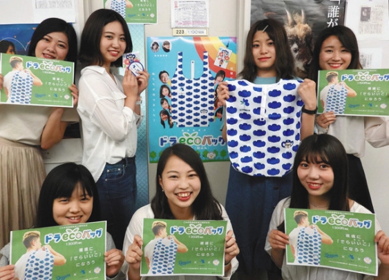 エコバッグやポップなどを手にする名古屋外国語大の横山ゼミの学生たち＝日進市の同大で