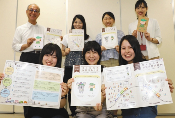 作った「第４次地域福祉活動計画」の冊子を手にする愛知淑徳大の学生たち＝千種区西崎町の区社会福祉協議会で